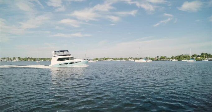Wide static shot of intercostal waterway in Hollywood, Florida with boat crossing frame. For projects requiring longer clips in higher resolution, visit StockPlates.