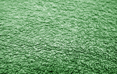 Green bath towel surface and texture close up with blur effect.