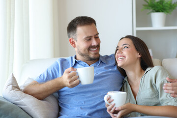 Happy couple enjoying drinking coffee at home