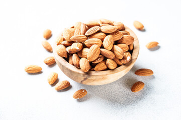 Almond nuts in wooden bowl at white background. Close up.