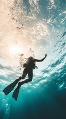 Underwater explorers are observing vibrant coral reefs while scuba diving in warm tropical waters during a sunny day. The sunlight filters through the waves