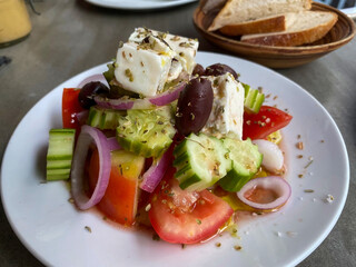 Greek salad with feta cheese, cucumber ,tomatoes, onions and black olives, served with bread.