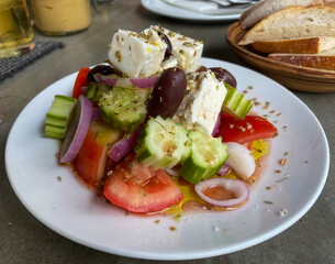 Greek salad with feta cheese, cucumber ,tomatoes, onions and black olives, served with bread.