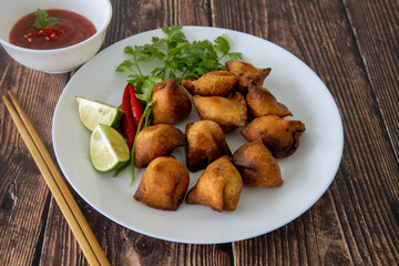 Indian fried Samosa filled with spiced potato, served with lime wedges and sauce