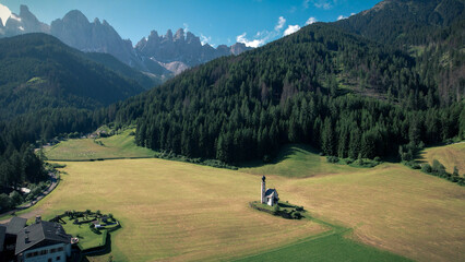 The Odle  Group mountain peaks and the Church of St. John in the Valley of Funes, South Tyrol in northern Italy. The small church of Ranui, is a symbol of South Tyrol's beauty.