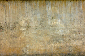 rough concrete wall with yellow streaks and stains
