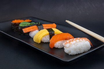 Selection of Japanese nigiri sushi on black plate