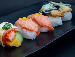 Selection of Japanese nigiri sushi on black plate