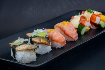 Selection of Japanese nigiri sushi on black plate