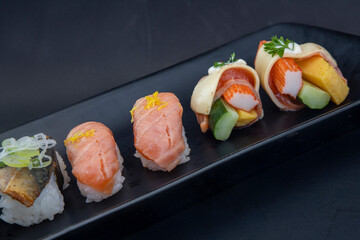 Selection of Japanese nigiri sushi on black plate