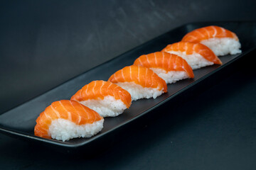 Japanese salmon nigiri on black plate