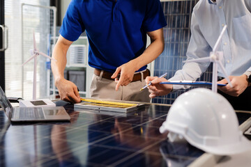 Two colleagues discussing data working and tablet, laptop with on Construction Site project, Clean energy and solar panel concept.