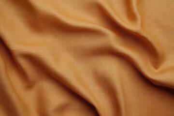 A close-up of soft, wrinkled golden fabric, showcasing its smooth texture and warm hue.
