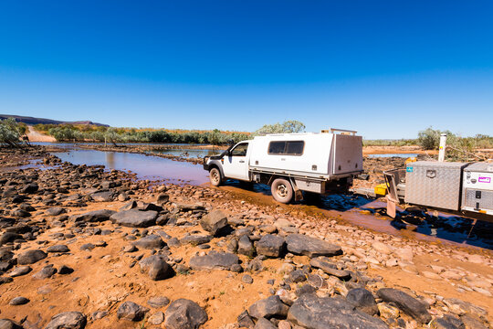 4WD vehicle towing a camper trailer crossing the Pentecost River