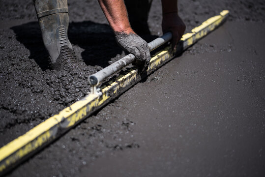 Concreter screeding black concrete