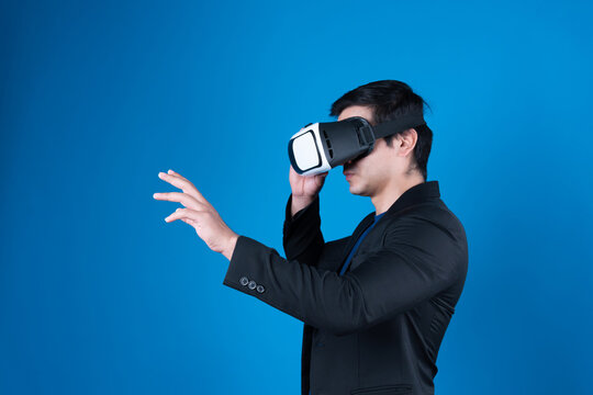 Profile businessman wearing VR headset looking to connect metaverse searching by touching slide with interesting data isolated blue background futuristic technology in virtual reality. Contrivance.