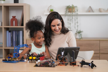 tutor providing a student in STEM lesson in class,a female teacher using tablet computer teach kid on robot circuits
