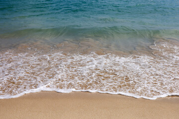 Empty sea beach with sand and blue wave. Background for holidays on a nature