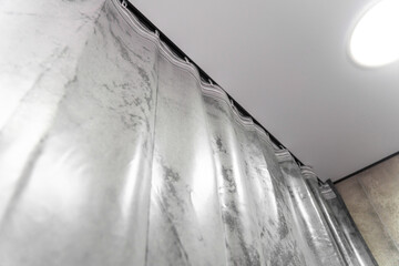 Modern gray curtains are hanging from a ceiling track system, adding a touch of elegance and style...