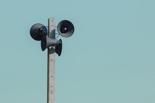 Vintage style amplifier installed on the electric pole wirelessly. The speaker receives waves and distributes sound signals for communication and public relations.
