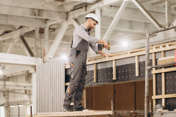 Construction worker building modular unit in factory