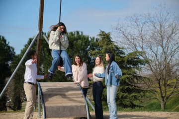 Obraz premium Group of cheerful multi ethnic young adult friends having fun together in a park, enjoying a sunny day outdoors