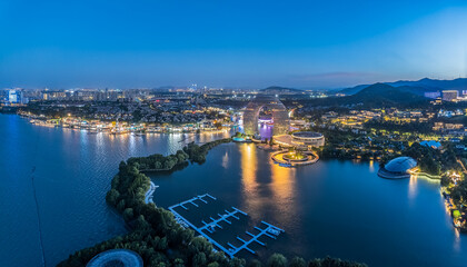Aerial view of illuminated resort buildings along lake coastline at dusk in Huzhou