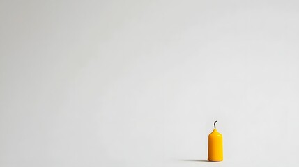 Obraz premium Single Yellow Candle on a Minimalist White Background Evoking Calm and Serenity