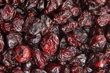 Macro image of dried cranberries showcasing deep red colors, wrinkled textures, and glossy surfaces, perfect for food and health-related visuals