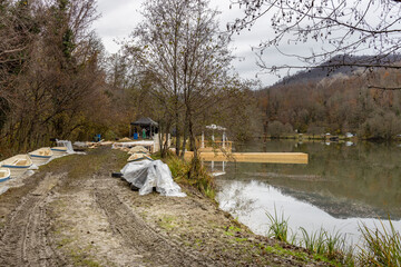 Muddy path leads to a lake with a dock