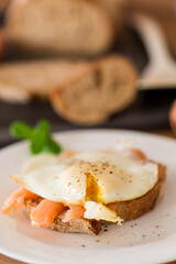 A slice of bread with a cooked egg and lightly salted red fish