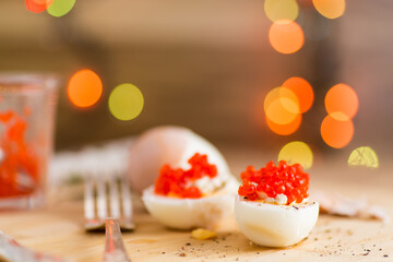 boiled eggs with red caviar on a blurred New Year's background