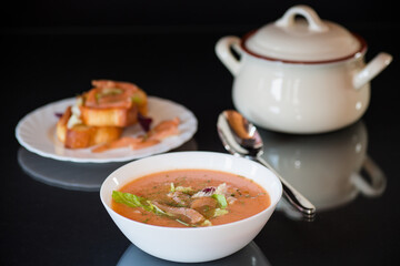 Thick and creamy cream soup of trout in a plate, isolated on black background