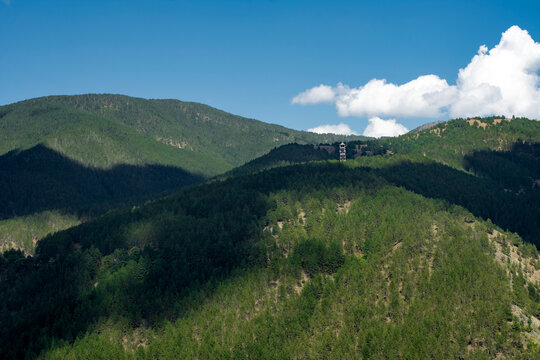 Mountain forest landscape with a fire watchtower on top of a hill