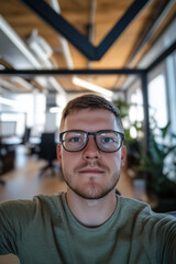 Smiling Young Professional With Glasses Taking a Selfie in Startup Workspace