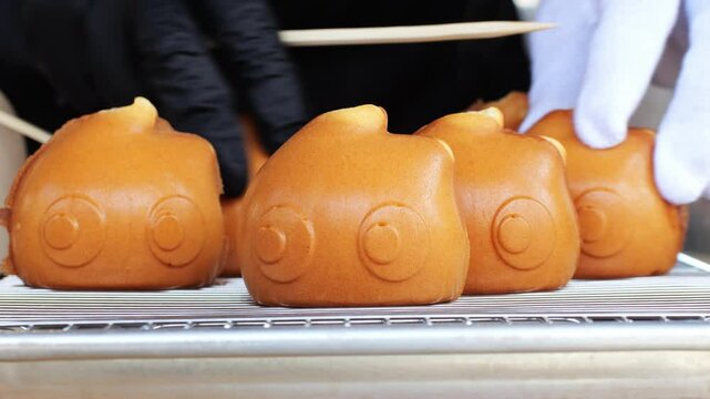 Tokyo street food sweets Ningyo - yaki. Japanese shaped sponge cakes, small baked pastries made in special molds, filled with sweet red bean paste - anko or custard cream.