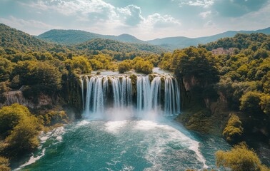 Fototapeta premium Majestic Waterfall Surrounded by Lush Green Forest and Rolling Hills Under a Bright Sky with Soft Clouds and Vibrant Blue Water Below