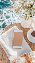 Summer Holiday: Mobile Device Display on Rattan Table with Sea View, Coffee, and Flowers - For Social Media Post