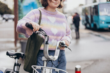 A young woman commuting to work on a bike in big city in the morning.