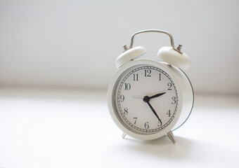 White clock placed on the table, leaving space for copying.