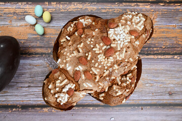 Colomba pasquale or Easter Dove is a traditional Italian dessert prepared with sourdough, almonds and candied fruit top view on wooden background isolated