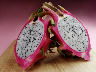 cut dragon fruit on a pink background.