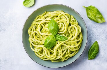 A bowl of creamy basil pesto pasta garnished with fresh basil leaves, showcasing a vibrant green color and a deliciously inviting appearance.