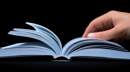 Naklejka premium A human hand turning the pages of an open book