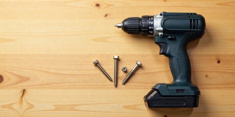Cordless drill and screws on a wooden surface ready for DIY project