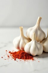 Aromatic Bulbs and Vibrant Red Spice Powder on a Smooth White Surface