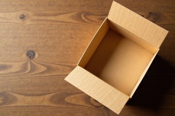 An empty cardboard box rests on a wooden surface, awaiting its contents; a simple yet versatile image ideal for showcasing products, concepts, or ideas.