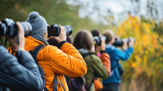 A photography workshop with participants taking pictures outdoors under the guidance of an instructor.