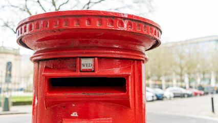 A red British post box on a city centre street