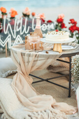 Beach Proposal Decor with Will You Marry Me Sign, Flowers and Cozy Area. Will You Marry Me Proposal